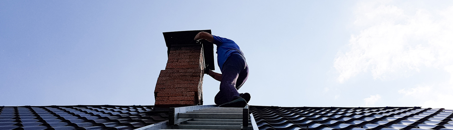 upshot view of worker on ladder repairing masonry chimney