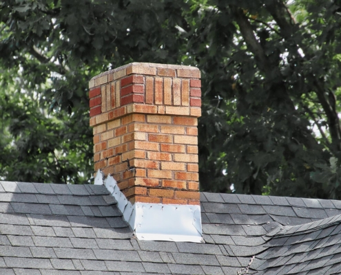 An old chimney on a shingles rooftop