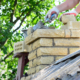 Repairing a brick chimney with bricklaying. Building contractor is rebuidling a chimney on a house