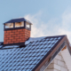 A chimney on a roof with smoke coming out of it